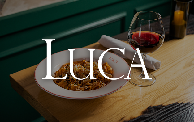 Luca logo overlaid on top of photo of wine and pasta